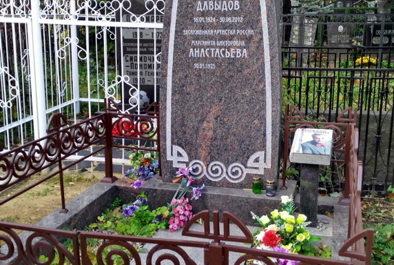 Оканчивающаяся православным крестом высокая стела из гранита