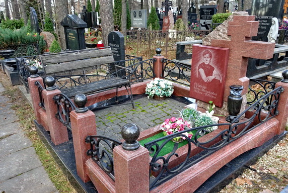 Табличка с информацией о покойном в нижней части массивного креста